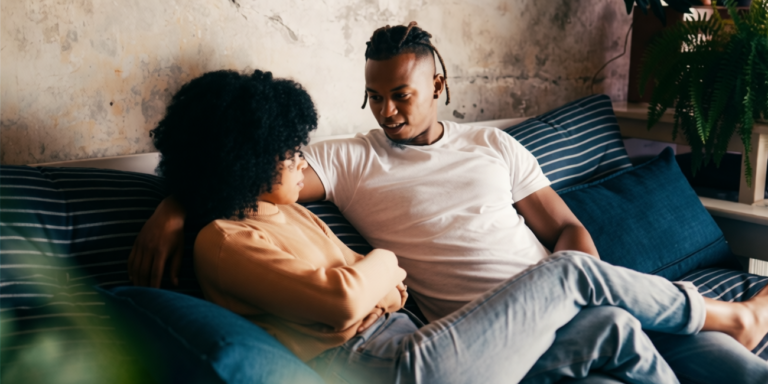 een man en vrouw zitten op een bank en kijken elkaar aan