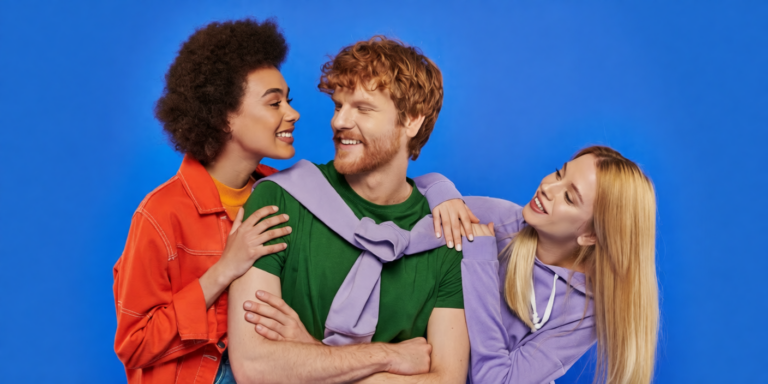 drie vrienden lachen en omarmen elkaar tegen een blauwe achtergrond