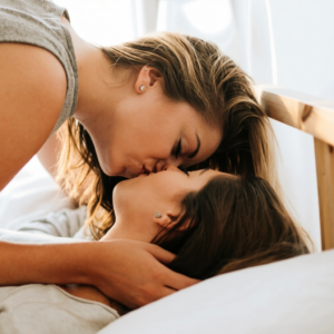 twee vrouwen die elkaar zoenen in bed