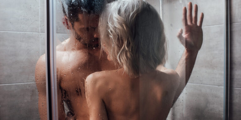naakte man en vrouw die elkaar kussen in de douche