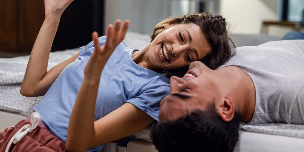 picture of a couple talking and smiling in the bedroom