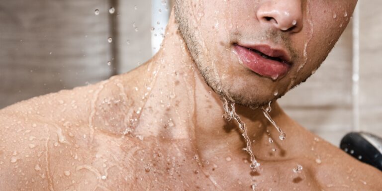 naakte schouders en hals van een man met waterdruppels op zijn huid