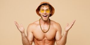 man met ontblootte borst, een hoed en zonnebril