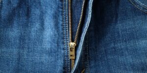 close-up van een metalen rits op een blauwe denim broek