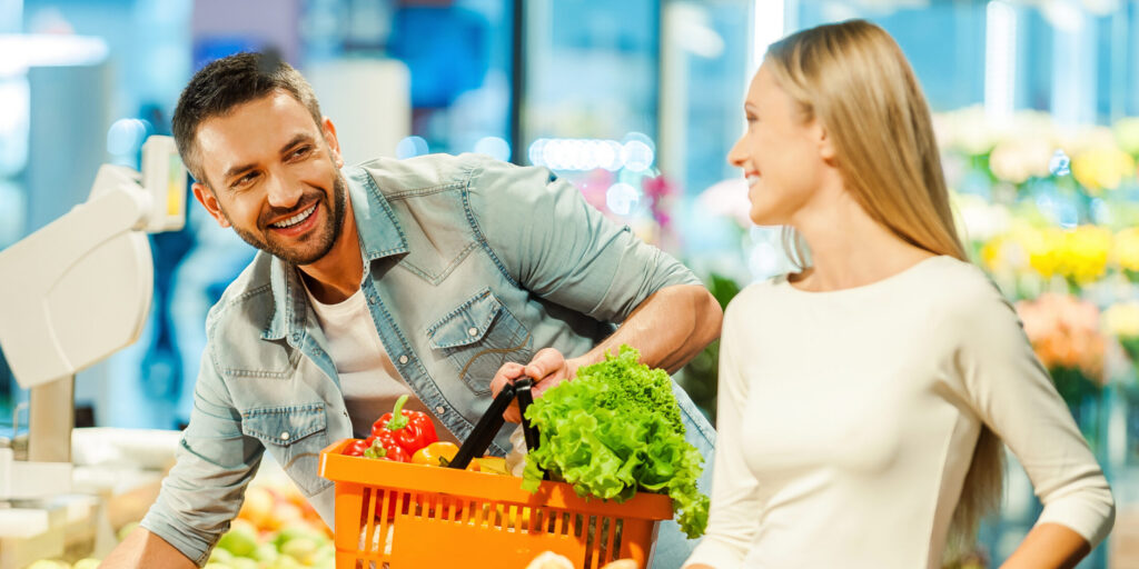 picture of a man and a woman in the grocery store, smiling at each other